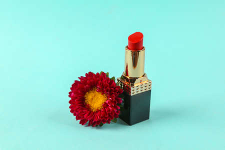 Red lipstick with red flower on blue backgroundの写真素材