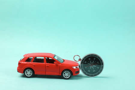 Toy car with compass on blue background. travel conceptの写真素材