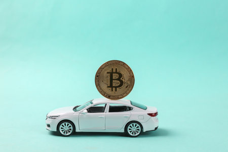 Toy car model with bitcoin on blue backgroundの写真素材
