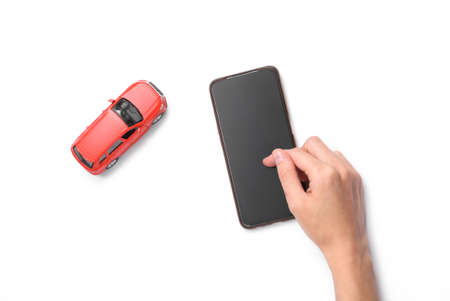 Search for a taxi. Hand using smartphone and toy car on white background