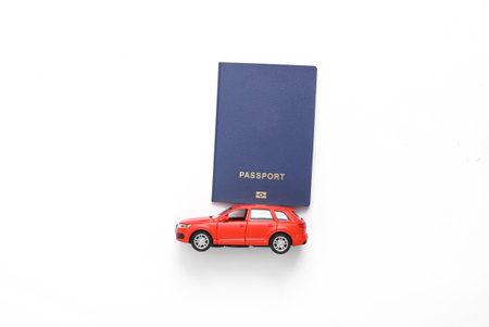 Toy car with passport on white background. travel concept. top viewの写真素材