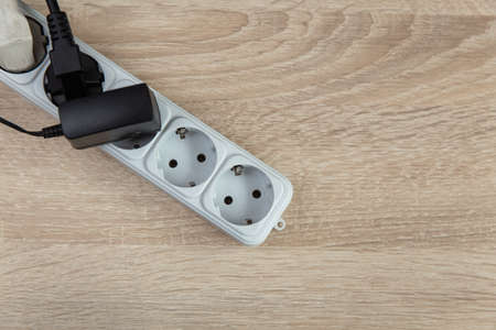 Electric extension cord on a wooden table. top view