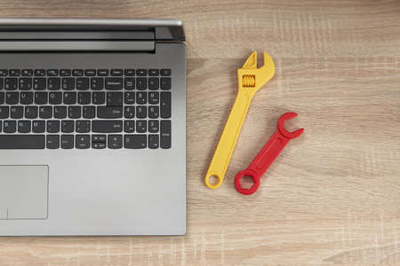 computer repair. Laptop with wrenches on wooden table