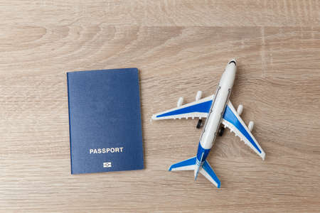 Toy model of passenger plane with passport on wooden tableの写真素材