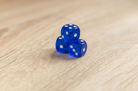 Blue dice on wooden table close up