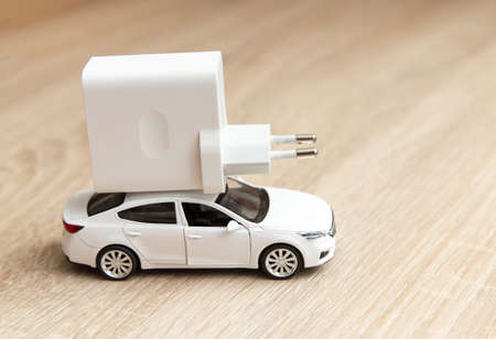 Car model with charger on wooden tableの写真素材
