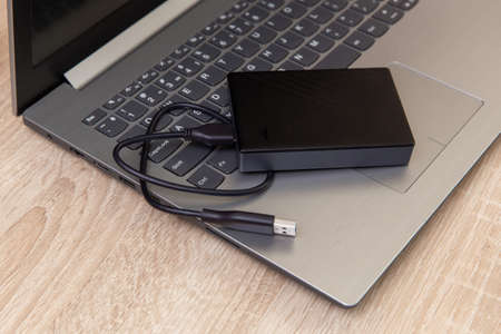 Laptop with External hard drive on wooden table