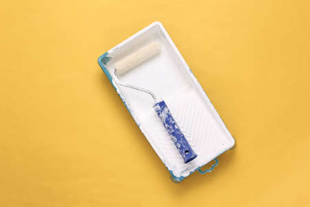 Painting roller on a yellow background. top viewの写真素材