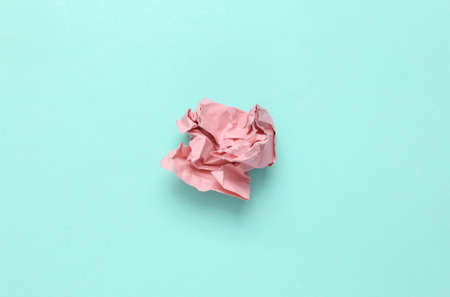 Pink crumpled sheet of paper on light blue background. Minimal still lifeの写真素材