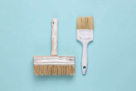Two paint brushes on a blue backgroundの写真素材