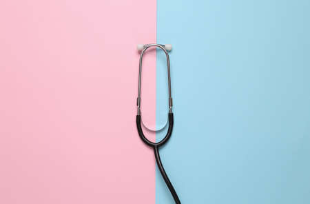 Fragment of medical stethoscope on blue pink pastel background