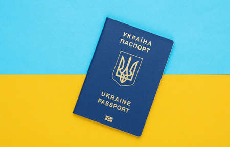 Ukrainian biometric passport on a yellow-blue background of the flag of Ukraine. Migration, travel conceptの写真素材