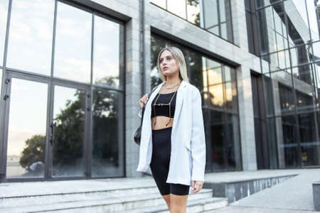 Young fashion blonde woman in trendy outfit posing in the city. street fashion