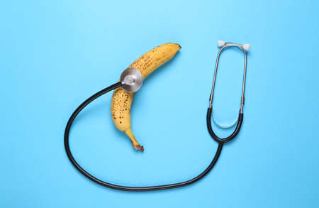 Bana with a stethoscope on a blue background. Treatment of male diseases, dysfunctions of the sexual systemの写真素材