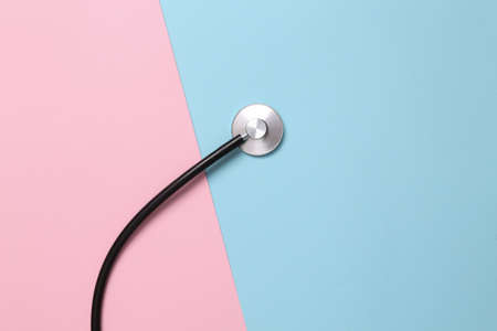 Fragment of medical stethoscope on blue pink pastel backgroundの写真素材