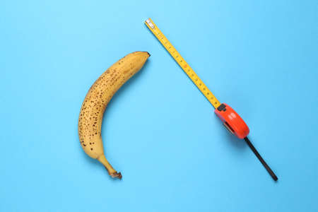 Banana with a ruler on a light blue background. top view. sex conceptの写真素材