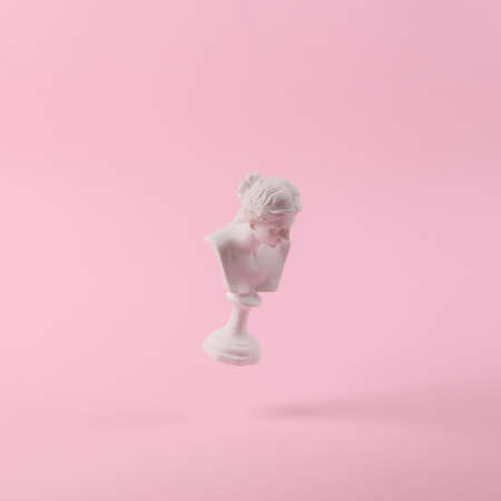 Levitating Antique Plaster bust of venus on pink background with shadow. concept pop. Minimal still life photographyの写真素材