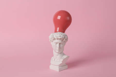 Antique David bust with pink light bulb on pink background. concept pop. Minimal still life. creative ideasの写真素材