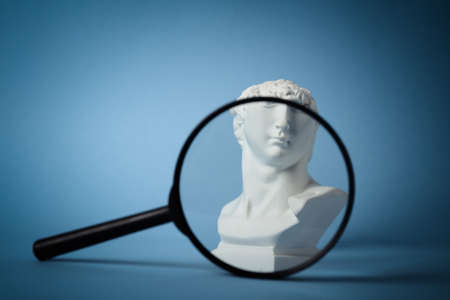 David's bust through magnifying glass on blue backgroundの写真素材