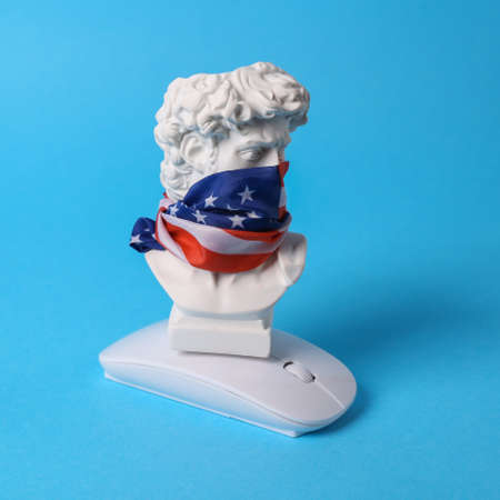David bust with usa flag on his face and pc mouse against blue background. political games. Patriot blog. Minimal still lifeの写真素材