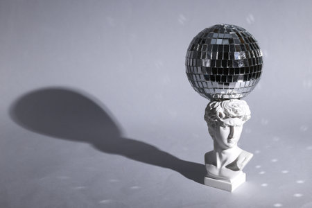 Bust of David with a disco ball on gray background with shadow. Minimal party concept. creative...