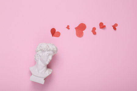 David bust with hearts on pink background. creative love layout. concept pop. Minimal still life. flat lay. top viewの写真素材
