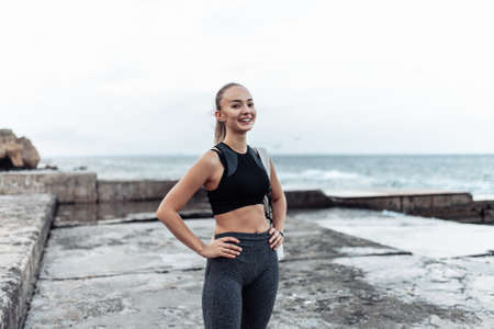Portrait of young fit woman in sportswear on urban beachの写真素材