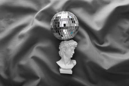 David plaster bust with mirror disco ball on gray crumpled silk background