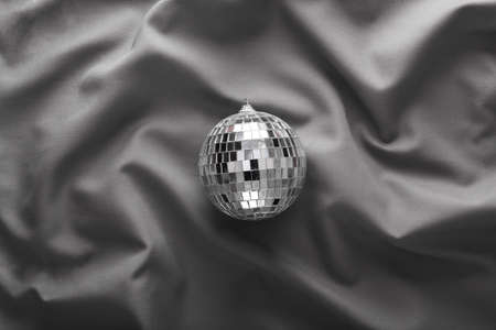 Mirror disco ball on gray crumpled silk background