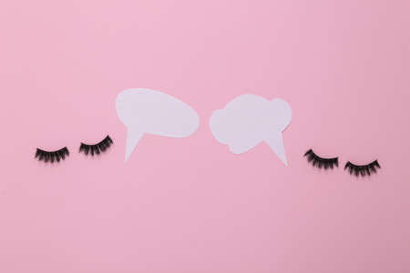 False eyelashes with dialog clouds on blue background. Minimal still lifeの写真素材