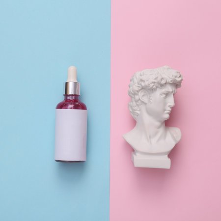 David bust with serum bottle on a pink blue background. skincare conceptの写真素材