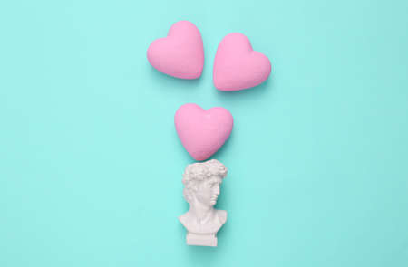 David bust with hearts on a turquoise background. Love, Valentine's Day February 14 concept. flat layの写真素材