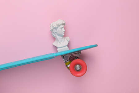 David bust on a skateboard. pink background. minimal popの写真素材