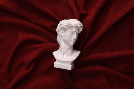 David plaster bust on red crumpled silk backgroundの写真素材