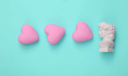 David bust with hearts on a turquoise background. Love, Valentine's Day February 14 concept. flat layの写真素材