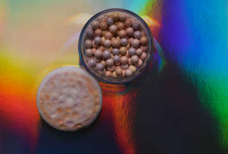 Powder balls on a holographic multicolored backgroundの写真素材