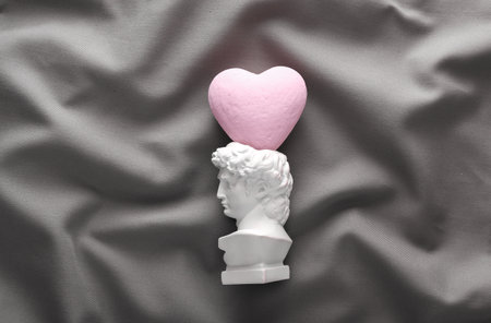 David plaster bust with heart on gray crumpled silk backgroundの写真素材