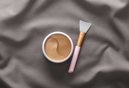 Golden eye patches in jar on gray silk backgroundの写真素材