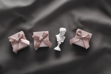 Venus bust with gift boxes on gray fabric background