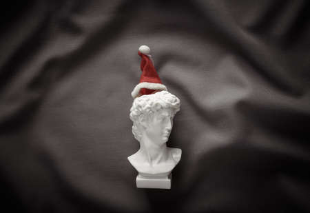 David bust with Santa hat on gray fabric crumpled background