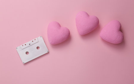 Audio cassette with hearts on a pink background. romantic melody. top viewの写真素材