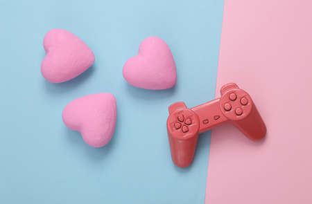 Gamepad and hearts on pink bue background. love concept. top view