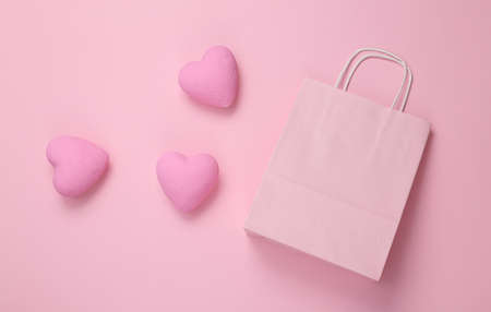 Shopping bag with hearts on pink background. love concept. top viewの写真素材