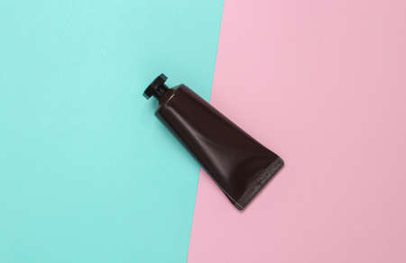 Mockup of black cream tube on pink blue background. top view. flat lay