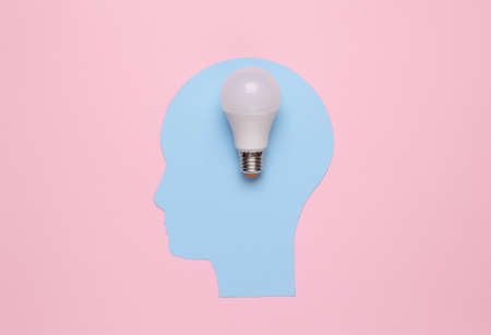 Cutted human head with a light bulb on pink background. idea conceptの写真素材
