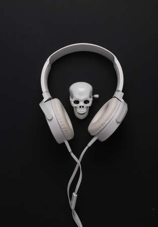 Skeleton skull with headphones on a black background.の写真素材