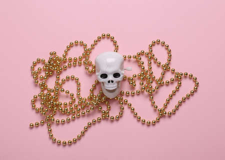 Skeleton skull with a Christmas garland on a pink background. top viewの写真素材