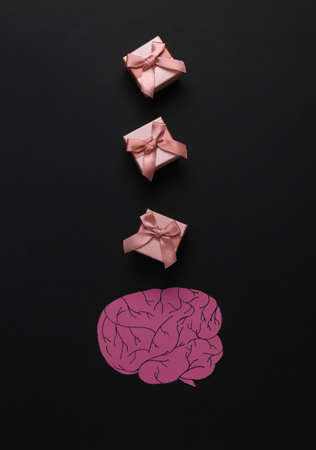 Paper cut brain with gift boxes on black background