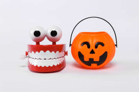 Toy jaw and Halloween jack pumpkin bucket isolated on white background. Trick or Treat