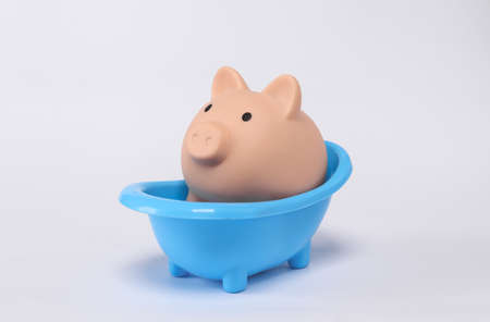 Piggy bank in bathtub isolated on white backgroundの写真素材